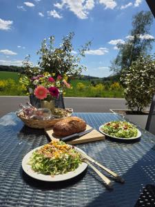 a table with two plates of food on it at Ferienhaus Eifel Horizont in Neuheilenbach