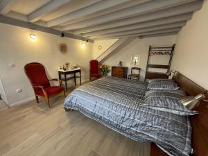 a bedroom with a bed and a table and chairs at La ferme des Gabelles in Saint-Benoît-sur-Loire