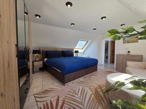 a bedroom with a bed with a blue bedspread at Ferienhaus Eifel Horizont in Neuheilenbach