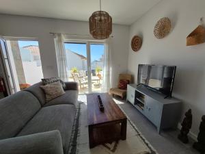 a living room with a couch and a tv at Ribavilla Surf House in Santo Isidoro