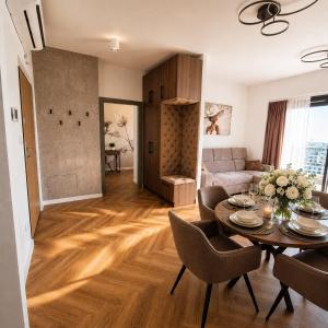a living room with a table and chairs and a couch at Olszynki Park Elite Residence in Rzeszów