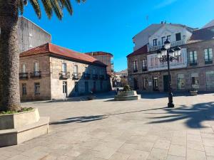 ein Stadtplatz mit Gebäuden und einer Straßenlaterne in der Unterkunft Hotel Herbiña 3000 in Cambados + 29 Fotos