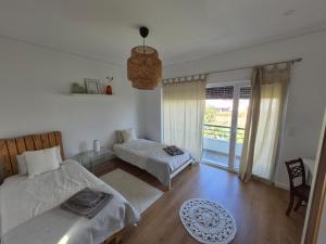 a bedroom with two beds and a balcony at Ribavilla Surf House in Santo Isidoro