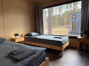 two beds in a room with a large window at SETO MAN Puhkekeskus in Värska
