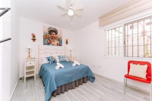 a bedroom with a bed and a red chair at Rinconcito in Almuñécar +16 photos
