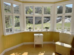 a room with windows and a chair and a table at Charming archipelago house in Grebbestad SE09082 in Grebbestad