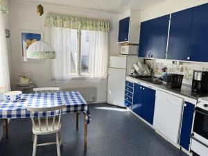 a kitchen with blue cabinets and a table and chairs at Charming archipelago house in Grebbestad SE09082 in Grebbestad