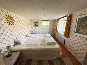 a bedroom with two beds and a clock on the wall at Charming archipelago house in Grebbestad SE09082 in Grebbestad