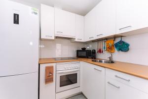 a white kitchen with white cabinets and a sink at Rinconcito in Almuñécar