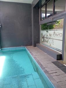 a swimming pool in front of a building at De La Charis Hotel in Kediri