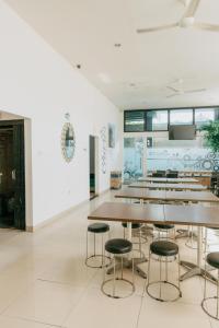 a dining room with tables and stools at De La Charis Hotel in Kediri