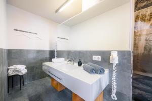 a bathroom with a white sink and a mirror at Hotel Garni Frommes in Fiss