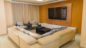 a living room with a white couch and a television at Hillview Executive Self-Catering House in Blantyre