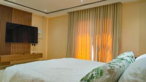 a bedroom with a bed and a flat screen tv at Hillview Executive Self-Catering House in Blantyre