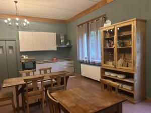 a kitchen with wooden tables and chairs in a room at Lodge Valchiavenna in Verceia