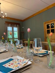 a table with wine glasses and pink flowers on it at Lodge Valchiavenna in Verceia