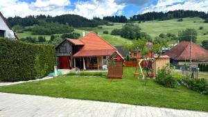 a house with a yard with a playground at Domček u Kubáňov in Bešeňová
