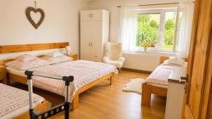 a bedroom with two beds and a window at Domček u Kubáňov in Bešeňová
