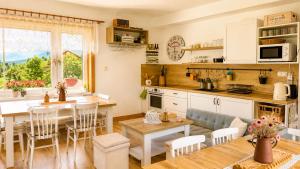 a kitchen and living room with a table and a dining room at Domček u Kubáňov in Bešeňová