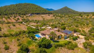 an aerial view of a house with a pool and a mountain at Ca na Margalida in Manacor