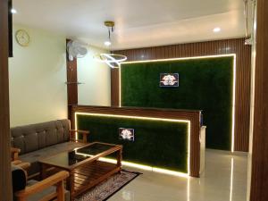 a living room with a couch and a green wall at Dev'S Inn Luxurious Homestays in Similigurha