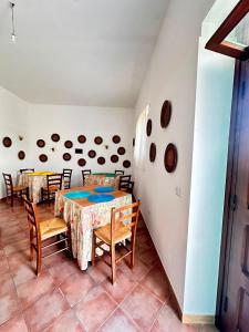 a dining room with a table and chairs at Giardino dei Trulli Cummerse in Faccia di Trippa di Monte +34 photos