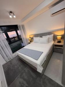 a bedroom with a large bed and a large window at B1 first line apartments in Šušanj