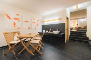 a dining room with a table and chairs and a bathroom at Hotel Garni Frommes in Fiss +22 photos