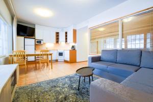 a living room with a blue couch and a table at Ehtookehto in Tahkovuori