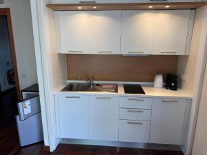 a kitchen with white cabinets and a sink at Apartment Giulia in Muggia