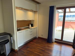 a kitchen with white cabinets and a large window at Apartment Giulia in Muggia +6 photos