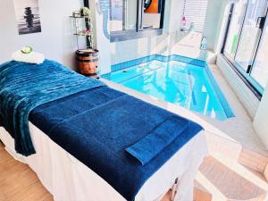 a swimming pool with a bed in a room at Calypso Sunset Accommodation in Langebaan
