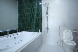 a white bathroom with a tub and a toilet at Cloud Rose Villa Hoi An in Danang +35 photos