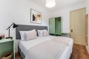 a bedroom with a white bed and a green cabinet at GuestReady - Vanzeleres Collection in Porto
