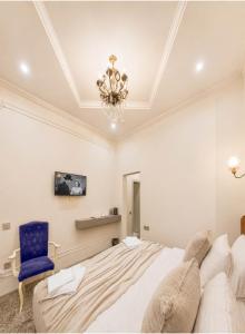 a bedroom with a bed and a blue chair at Old Money Boutique Hotel in Baku