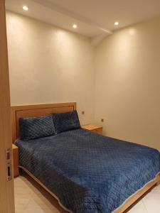 a bedroom with a bed with a blue comforter at Easy Stay Agadir in Agadir