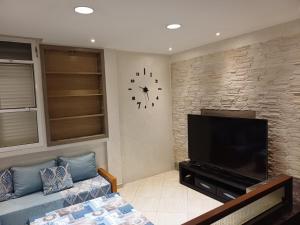 a living room with a couch and a clock on the wall at Easy Stay Agadir in Agadir