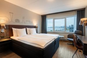 a hotel room with a bed and a desk and a window at Radisson Blu Limfjord Hotel, Aalborg in Aalborg +32 photos