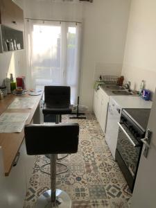 a kitchen with two bar stools in a kitchen with a sink at Ma maison in Bonneuil-Matours