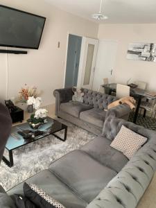 a living room with a couch and a tv at Ma maison in Bonneuil-Matours