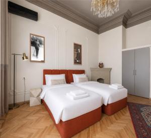 a bedroom with a large bed and a chandelier at Old Money Boutique Hotel in Baku