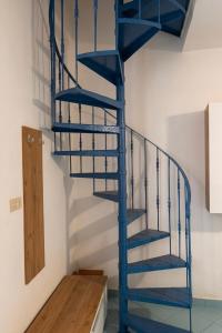 a blue spiral staircase in a room at Onda Blu House in Procida