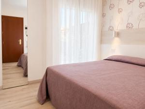 a bedroom with a bed and a large window at Hotel Da Mario in Caorle