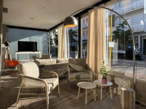 a living room with chairs and a couch and a tv at Hotel Da Mario in Caorle