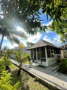 a house with a palm tree in front of it at Selong Belanak Bungalows in Selong Belanak
