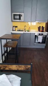 a kitchen with a table and a sink and a microwave at neu renoviert private zimmer mit Bad und Küche in Rostock