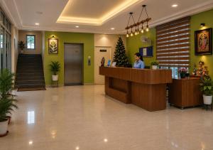 a woman standing at a counter in a lobby at Joygaon Hotel & Resorts in Jhajjar