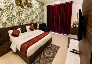 a bedroom with a bed and a television in it at Joygaon Hotel & Resorts in Jhajjar