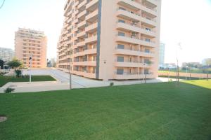 césped verde frente a un edificio en Apartamentos Paraíso Sol da Rocha, en Portimão