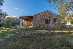 a small stone house with a stone wall at Profumo di Sardegna in Porto Istana